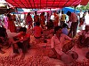 Selling vegetables under a red tarp